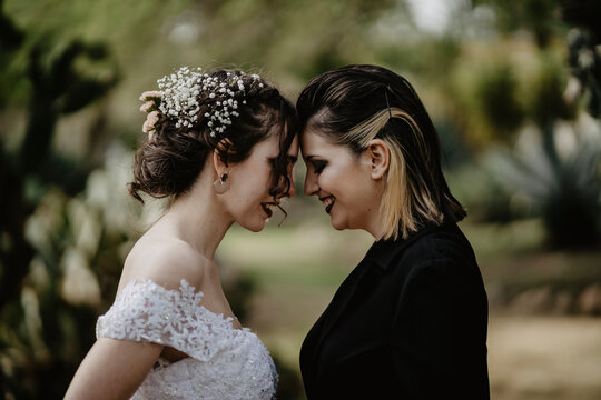 Happy brides touching foreheads in park