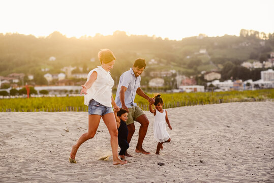 Diverse family with kids walking on beach
