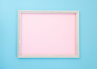 Wooden white frame inside pink, on a blue background, minimalism, mock up.