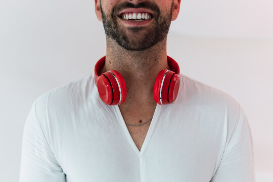 Anonymous cheerful man listening to music white background