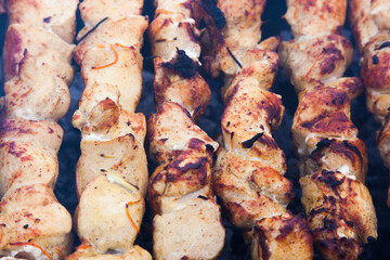 The meat is grilled on a grid over charcoal close-up.