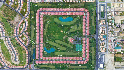 Square settlement and green area looking down aerial view from above – Bird’s eye view Palm...