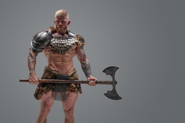 Fierce scandinavian soldier with naked torso and huge axe