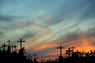 silhouettes of crowded tombs at sunset
