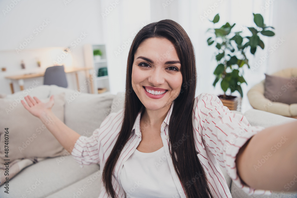 Poster self-portrait of attractive cheerful hospitable long-haired woman sitting on divan inviting home ind