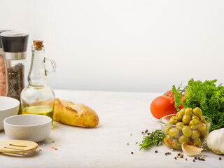 Fresh vegetables, herbs, green olives, baguette, olive oil, spices. Organic products. Salad preparation ingredients. Healthy lifestyle. Healthy vegetarian products.