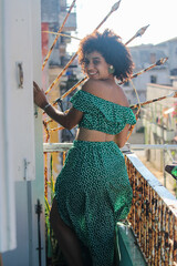 Young afro woman is standing happy in the balcony