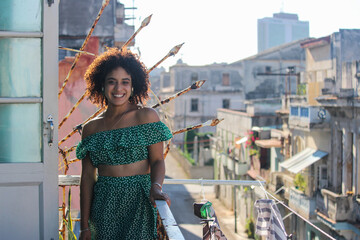 Young afro woman is standing happy in the balcony