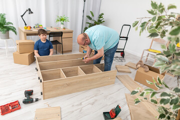 Dad is trying things on and seeing which screws to use. Assembling furniture.