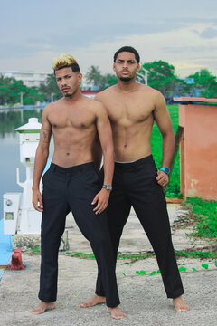 Two young Afro men talk on the coast. 