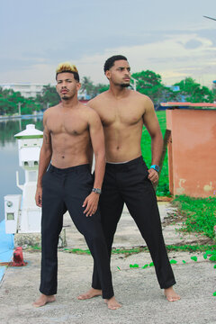 Two young Afro men talk on the coast. 