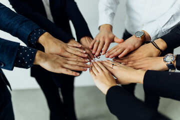 Fototapeta premium People of different ages and nationalities fold their hands on each other, symbolizing their unity and support. Team of people who are set up for productive work and a positive result.