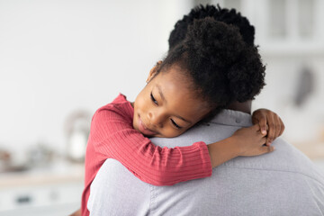 Obraz premium Smiling little black girl hugging her daddy