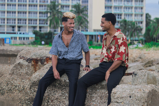 Two young Afro men talk on the coast. 