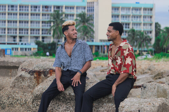 Two young Afro men talk on the coast. 