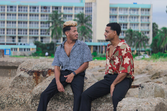 Two young Afro men talk on the coast. 