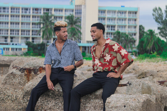 Two young Afro men talk on the coast. 