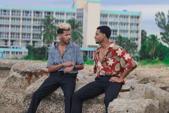 Two young Afro men talk on the coast. 