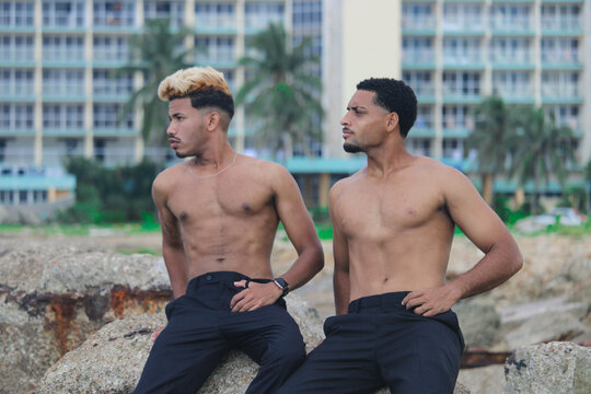 Two young Afro men talk on the coast. 