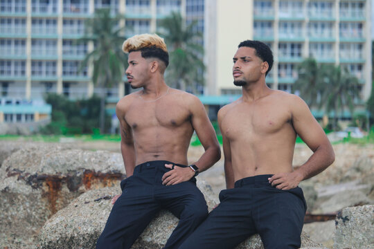 Two young Afro men talk on the coast. 