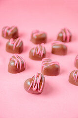 Chocolate bonbons in the shape of hearts with pink icing.
