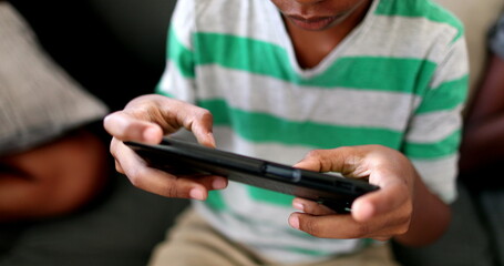 Child hands using cellphone close-up. African black ethnicity kid hand playing video-game with phone