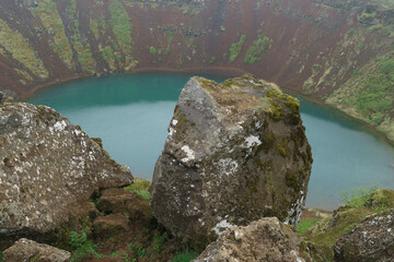 view of the Kerid crater lake in iceland with rock in front