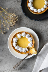 Lemon cake with a broken piece with a spoon. Composition top view on a gray stone background