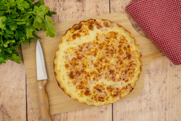 whole quiche lorraine on a wooden board