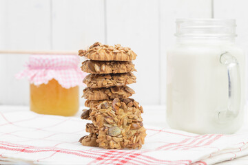 Sweet cookies and milk with honey on a wooden background