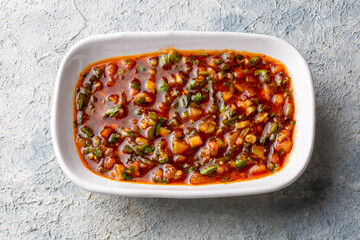 A spicy Turkish appetizer ezme made with tomatoes, bell pepper, parsley, mint, olive oil and hot chili.