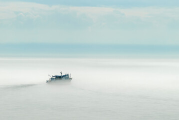 A ship sailing on the lake in the fog