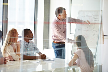 Motivating his staff through effective training. Shot of a group of business colleagues in a boardroom meeting.