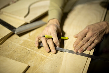 Guy marks board on ruler. Marking with pencil. Carpenter measures surface.