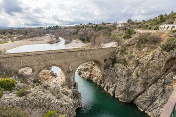 Fototapeta premium Vue sur le Pont du Diable à l’entrée des Gorges de l’Hérault par un temps nuageux (Occitanie, France)