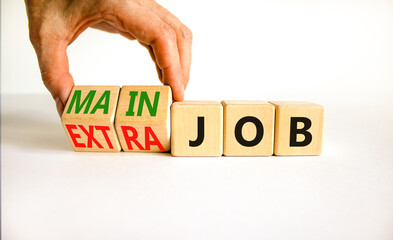 Extra or main job symbol. Businessman turns wooden cubes and changes concept words Extra job to...
