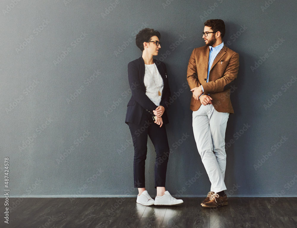 Aufkleber You can learn a lot from your colleagues. Shot of two designers having a conversation while leaning against a wall.
