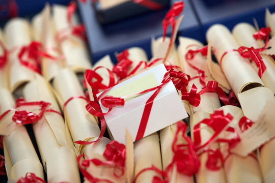 Award rolls made of paper and decorated with red ribbons, prepared for an academic ceremony
