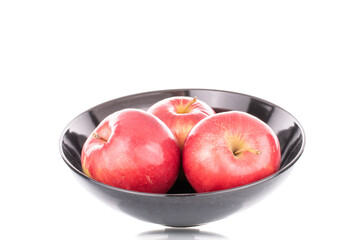 A few sweet organic, red apples with a black ceramic plate, macro, isolated on a white background.

