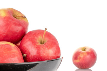 A few sweet organic, red apples with a black ceramic plate, macro, isolated on a white background.

