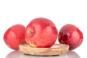 Three sweet organic, red apples with wood saucer, macro, isolated on white background.

