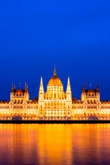 Detail of the illuminated parliament building in Budapest, Hungary, in the evening - Parliament in Budapest illuminated at dusk