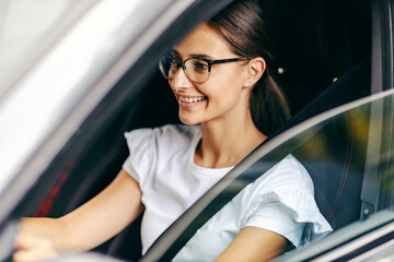 A young girl just got a driving license and she is ready to drive. 