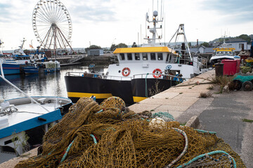 A fishing boat with its nets in a port in Normandy, France