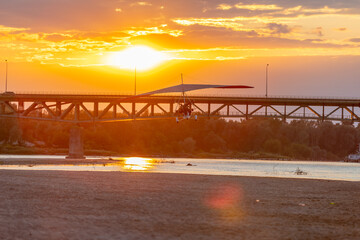 A motor glider at sunset over the bridge