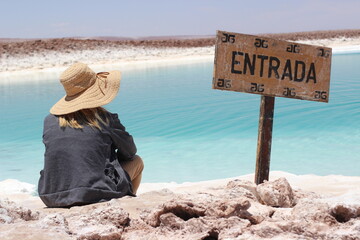 chapéu pessoa observa o azul da piscina de sal no deserto Atacama