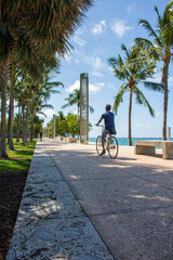 Fototapeta na wymiar A summer afternoon and fun riding a bike in a park in by front Miami