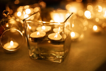 burning candles on a dark night in a wooden lantern