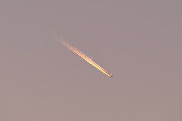 Naklejka na ściany i meble Distant passenger jet plane flying on high altitude on clear blue sky leaving white smoke trace of contrail behind. Air transportation concept