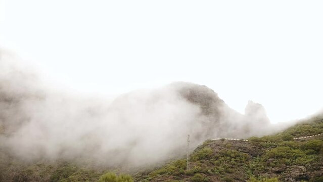 Aerial top view of transportation asphalt road across mountain with fog and clouds